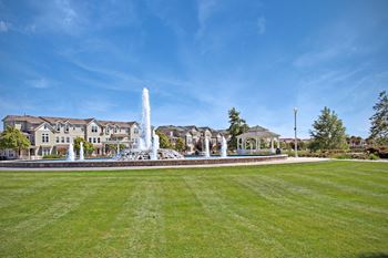 a fountain in a park in front of a house at The Vines at Riverpark, LLC, California